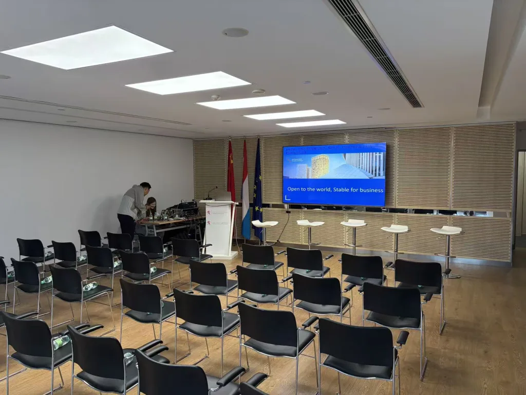 HI-COM technician testing bidirectional English-Chinese AI translation and live captioning equipment before an event