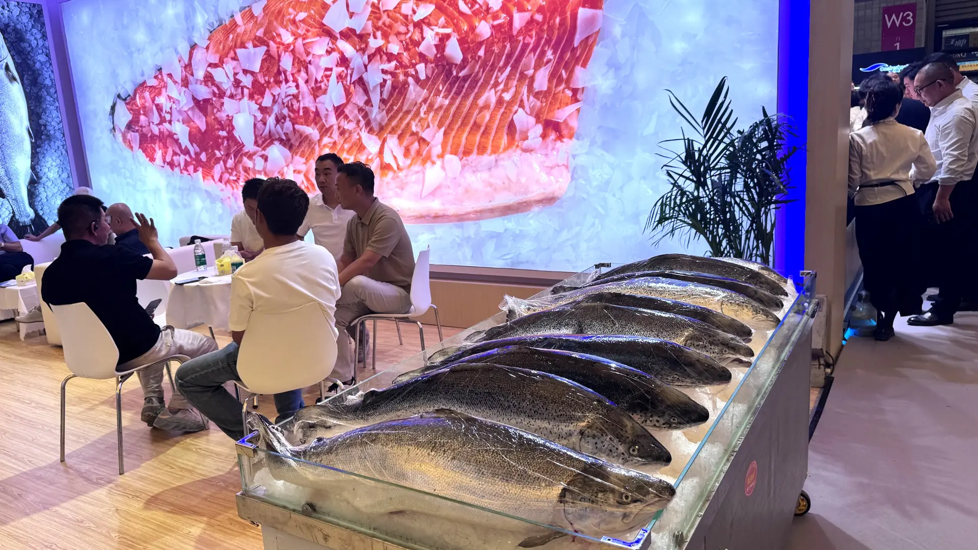 Trade-show representative presenting seafood products to business visitors during a booth activation in China.