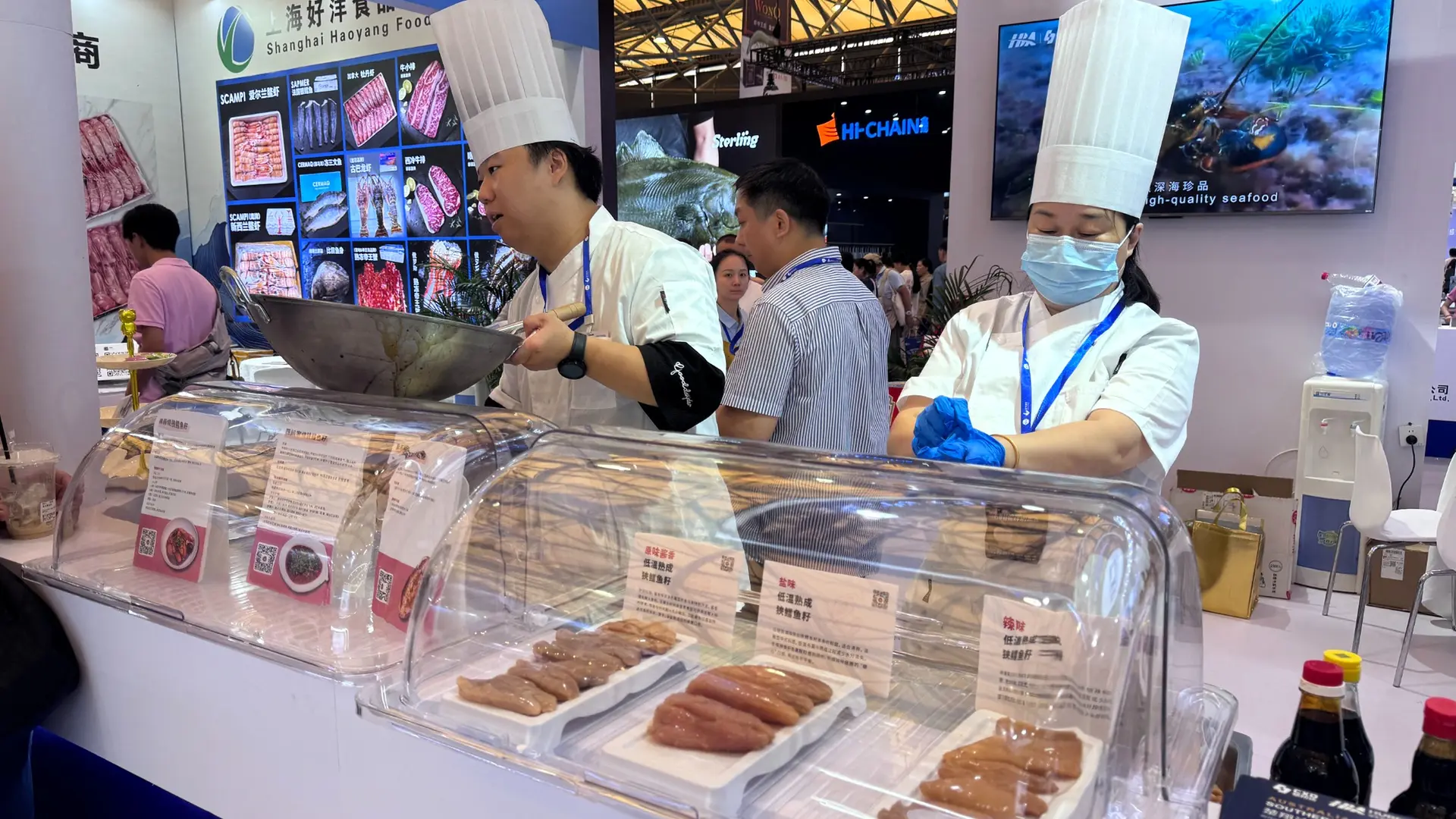 Chef leading a live cooking demonstration at a seafood exhibition booth activation in China.