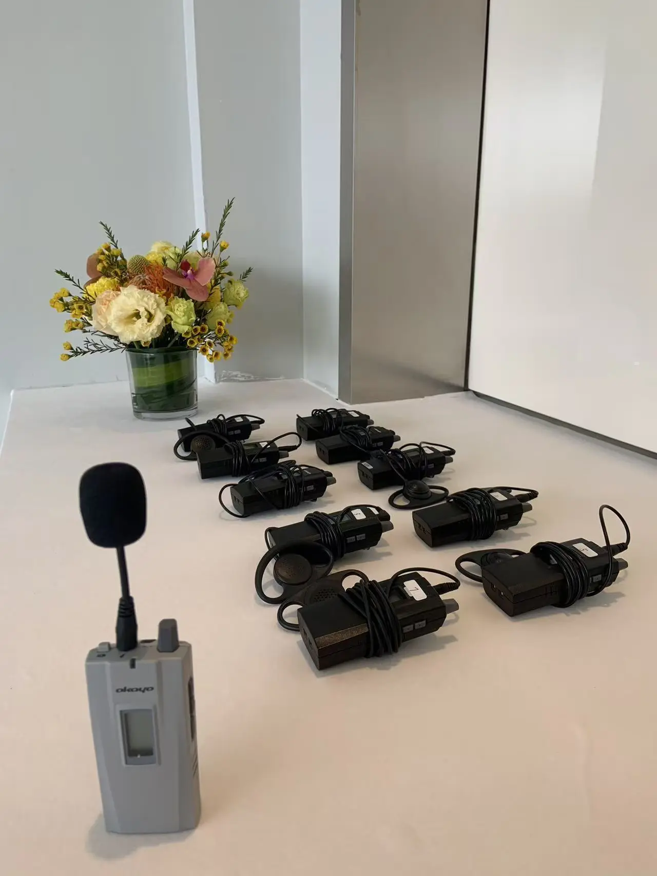 Okayo wireless tour-guide interpreting receivers and headsets laid out and ready for a HI-COM delegation visit in China