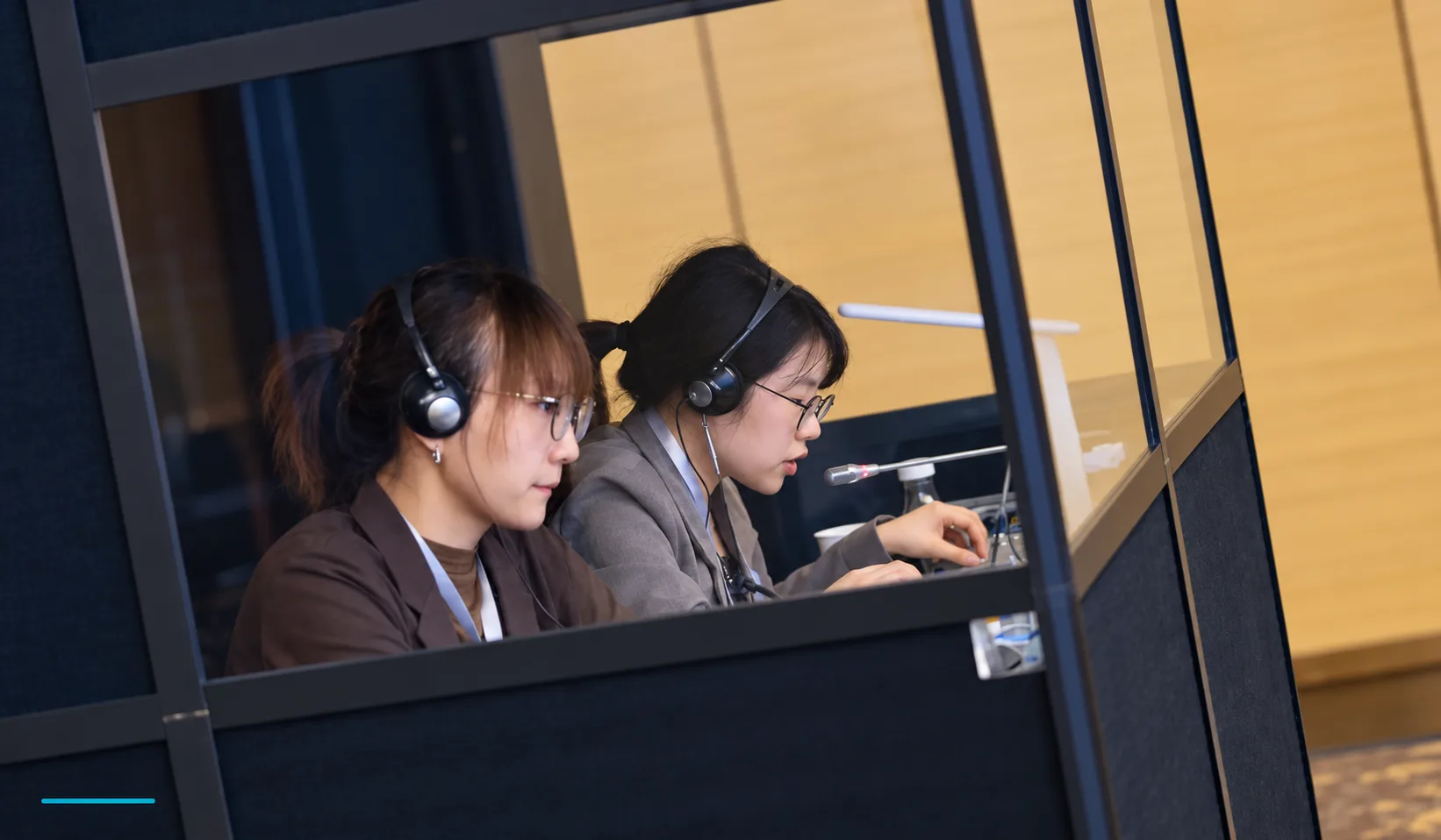 HI-COM simultaneous interpreters working in an interpretation booth at a business event in China
