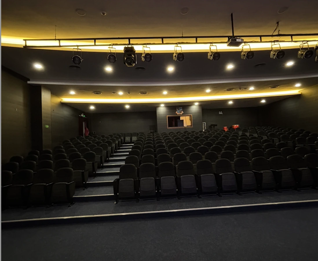 Rows of seats and overhead lighting in the Britannica Shanghai auditorium before an event.