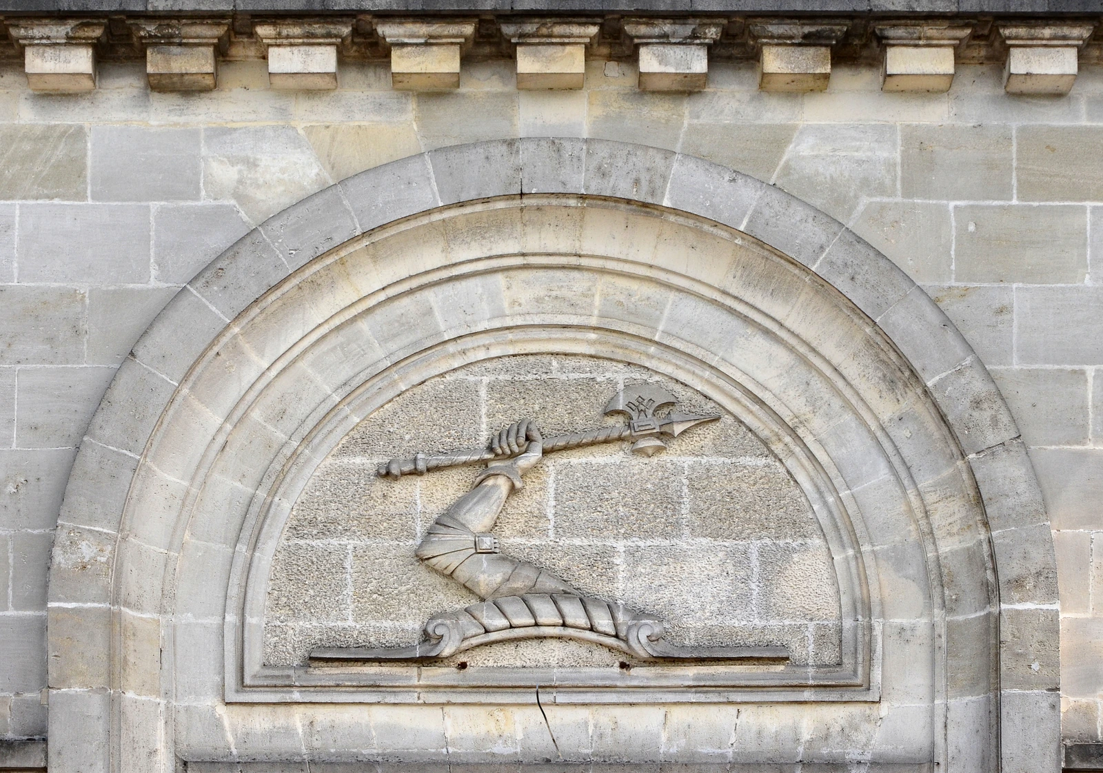 Hennessy's carved arm-and-axe emblem set into a stone arch in Cognac, France.