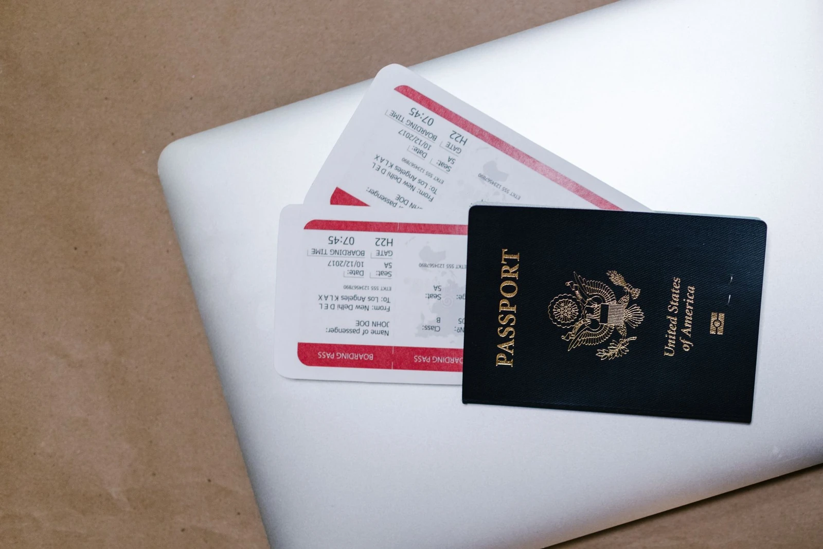 Passport and boarding passes on top of a laptop during travel preparation for a family visit to China.