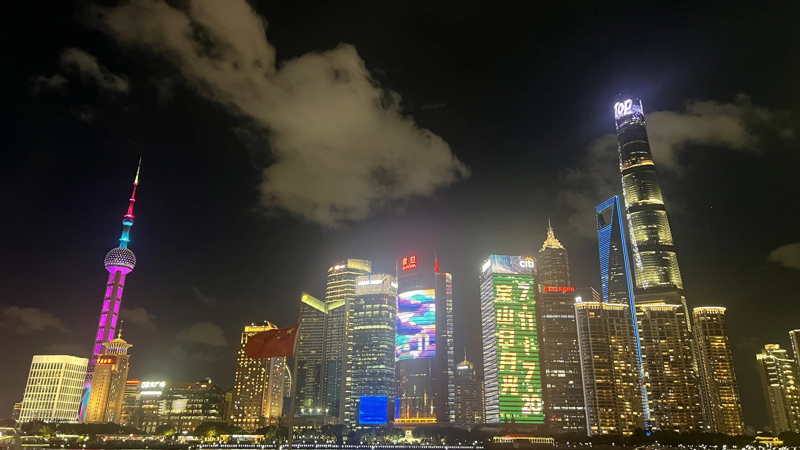 Illuminated Lujiazui skyline in Shanghai across the Huangpu River at night.