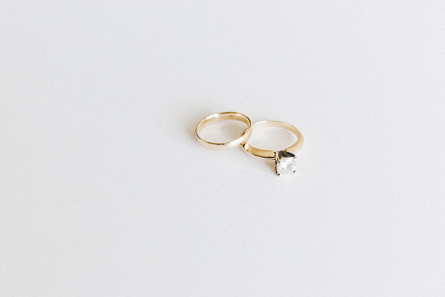 Two wedding rings on a pale surface, illustrating the marriage context of a family visa application.